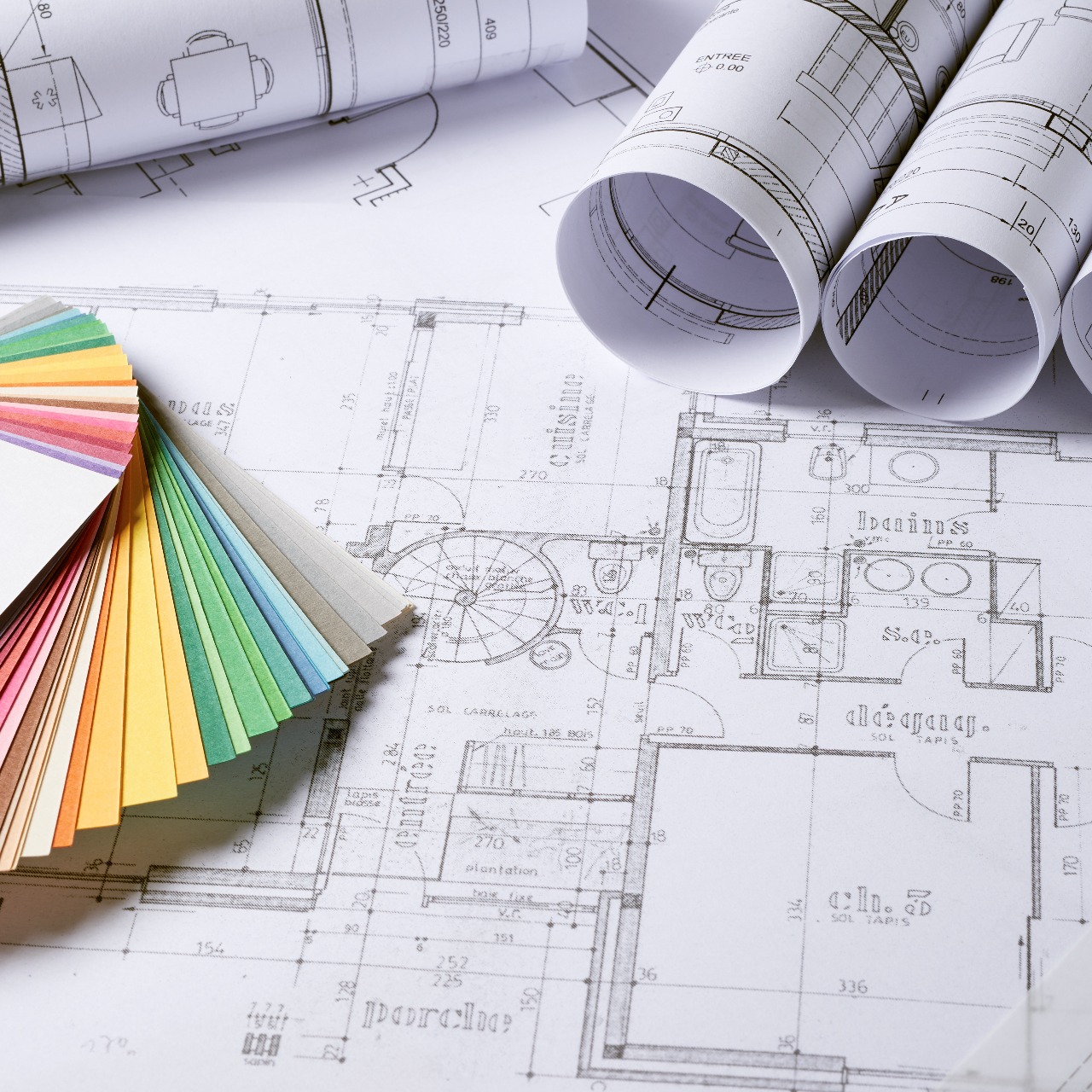 Plans architecturaux et nuancier coloré sur table.